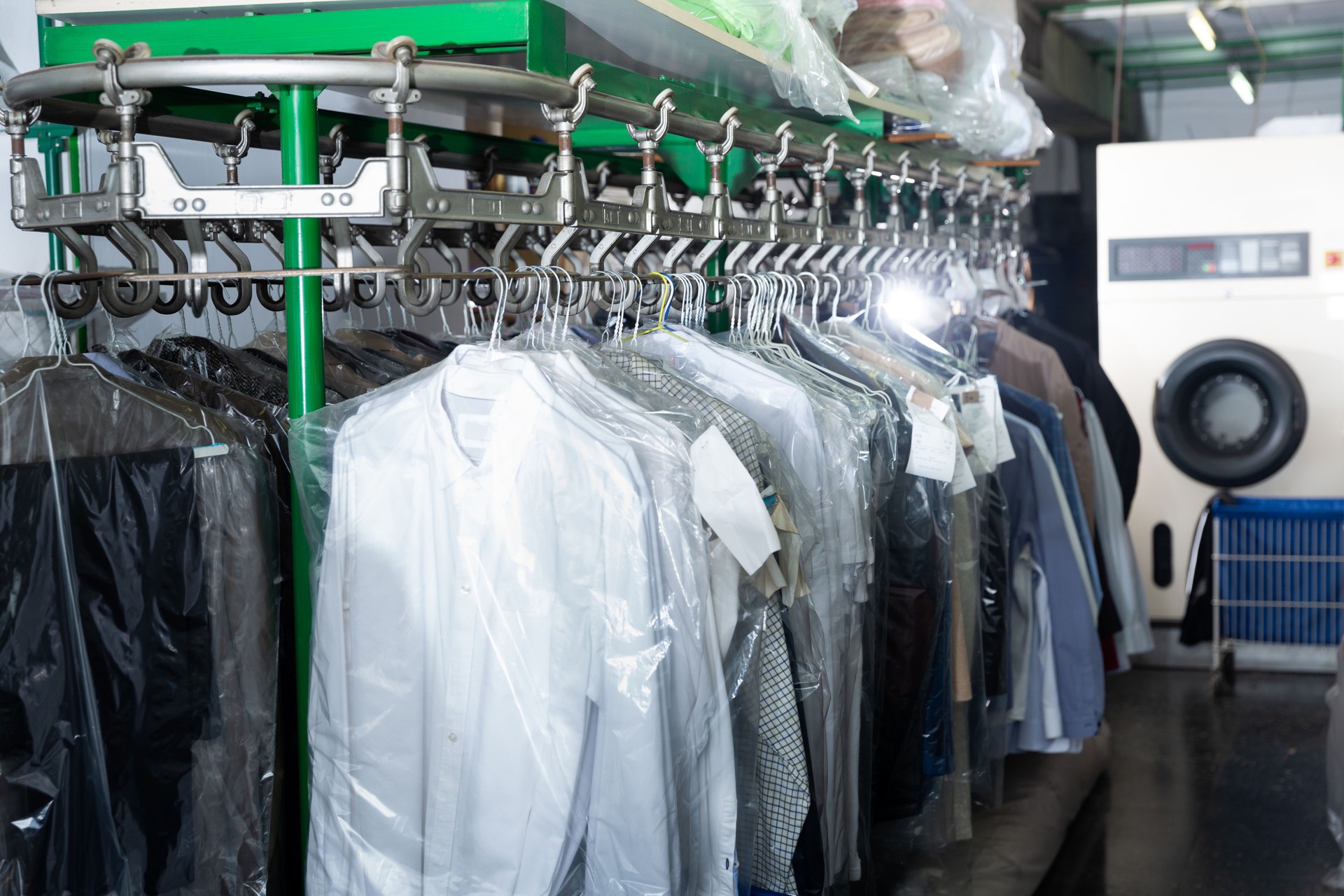 Clothes in plastic bags hanging at dry-cleaning